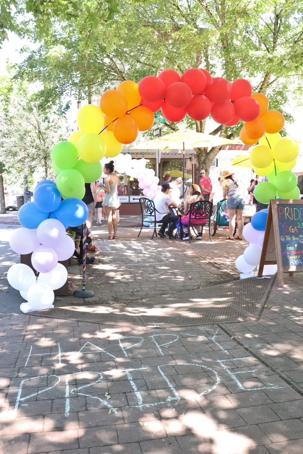 A rainbow balloon arch and a chalk message welcome attendees to Lewis County Pride at Pine Street Plaza in Centralia on Saturday.