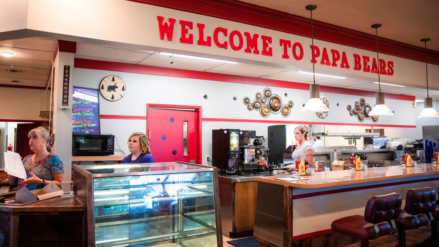 A wall sign reads “Welcome to Papa Bears” on opening day.