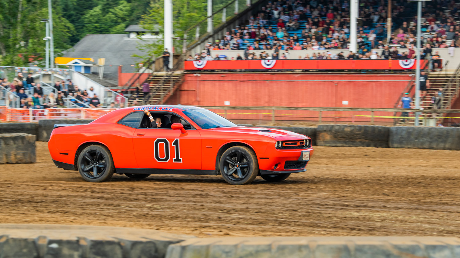 A Dodge Challenger with “General Lee,” decals spins tires in the Southwest Washington Fairgrounds grandstand arena Sunday night during Summerfest celebrations.