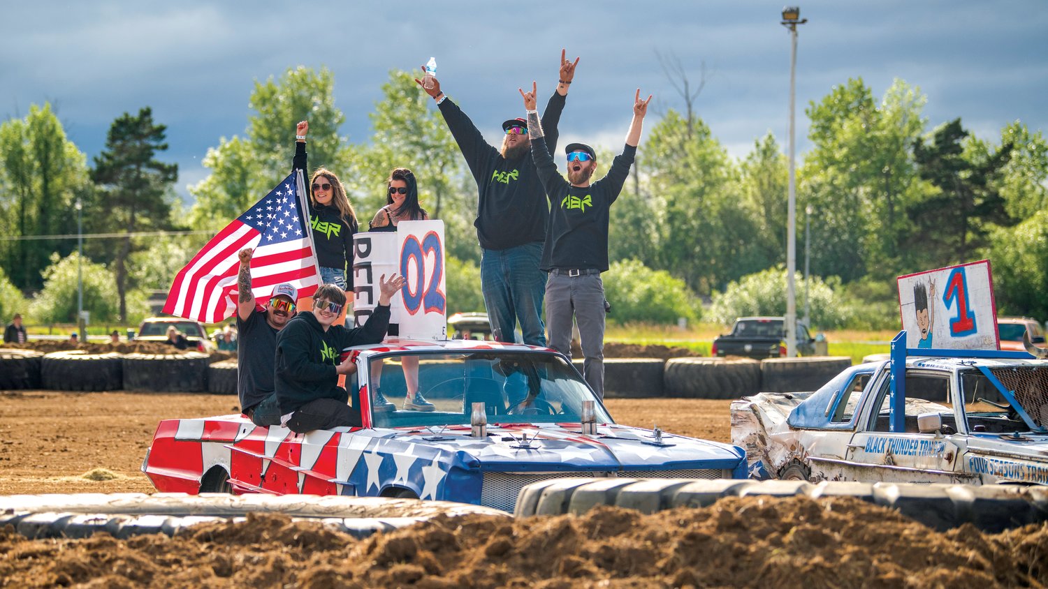 The HBR crew, and driver Brad Hunter, cheers with the crowd as their vehicle wins “prettiest car,” during the Summerfest Demolition Derby at the Southwest Washington Fairgrounds Sunday in Centralia.