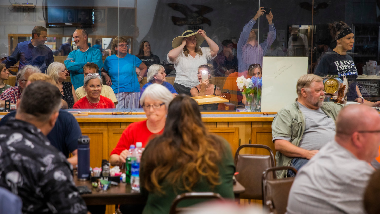 Visitors listen and record a Lewis County Republicans meeting at the Chehalis Eagles Aerie Monday evening.