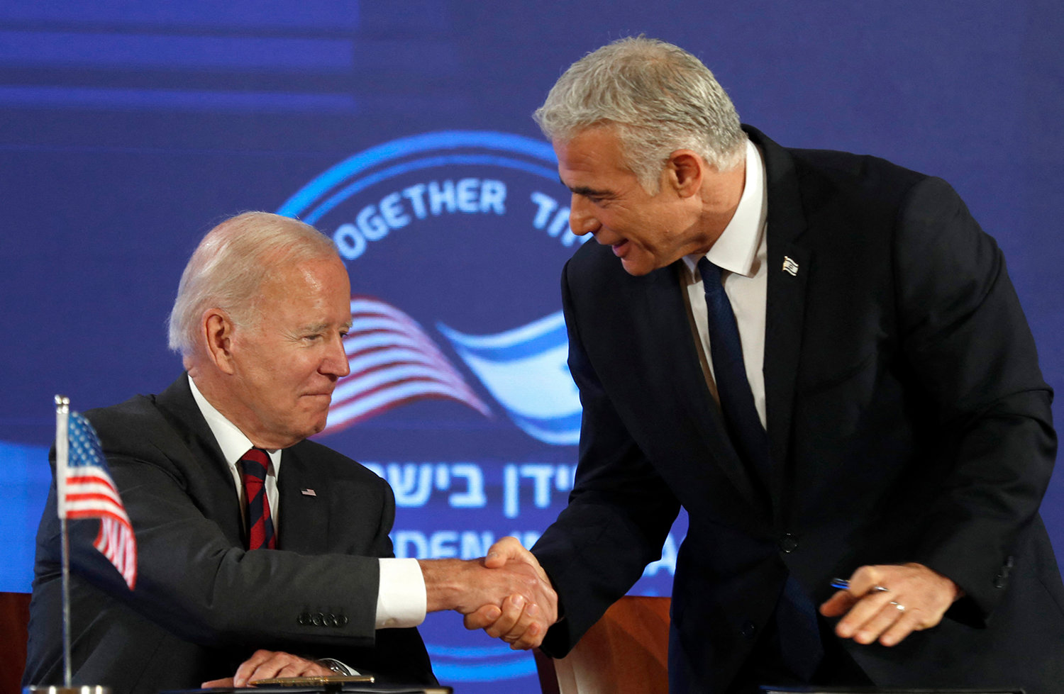 US President Joe Biden (left) and Israel's caretaker Prime Minister Yair Lapid, shake hands before signing a security pledge in Jerusalem, on July 14, 2022. (Atef Safadi/Pool/AFP via Getty Images/TNS)