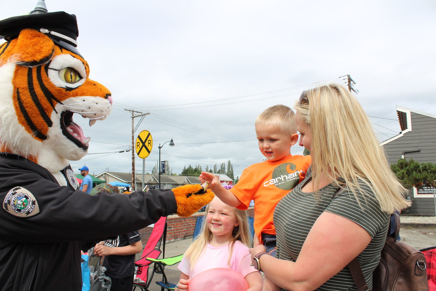 Alicia Nakano, a Napavine resident and Princess Napawinah 1999, and her children Brinley, 6, and Carter, 3, are greeted by the Napavine Tiger during Napavine Funtime Festival Saturday.