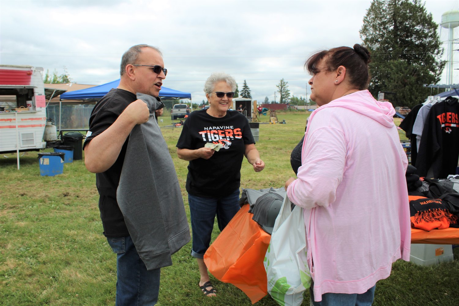 Fairly new Napavine residents Doug and Monique Ship buy some hometown swag from Marianne Wilcox at the Napavine Booster Club booth at Napavine Funtime Festival.