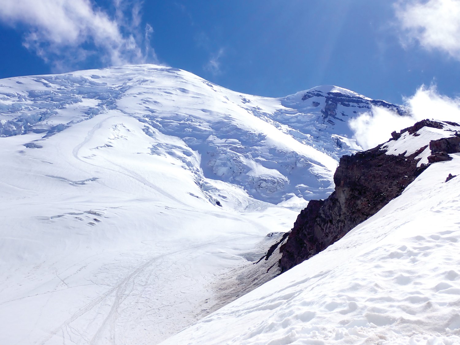 Rocks, clouds and snow surround the summit of Mount Rainier.