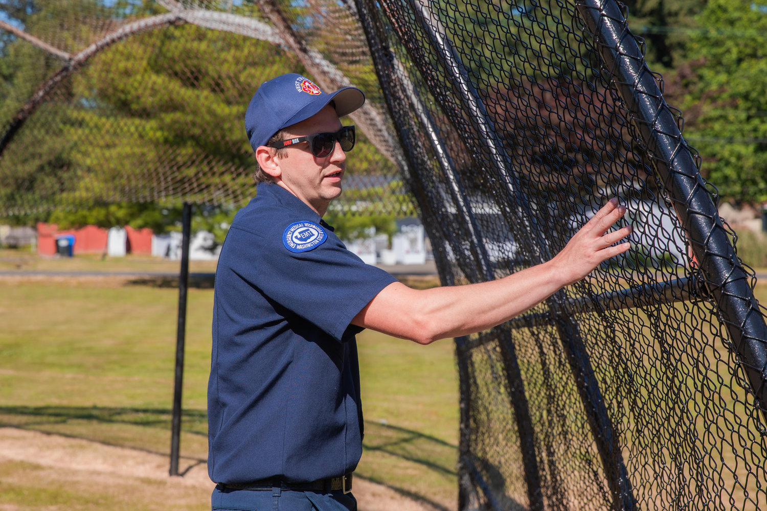 West Thurston Firefighter Chris White points out new fencing and paint around a baseball field outside the Scott Lake Community Center near Maytown.