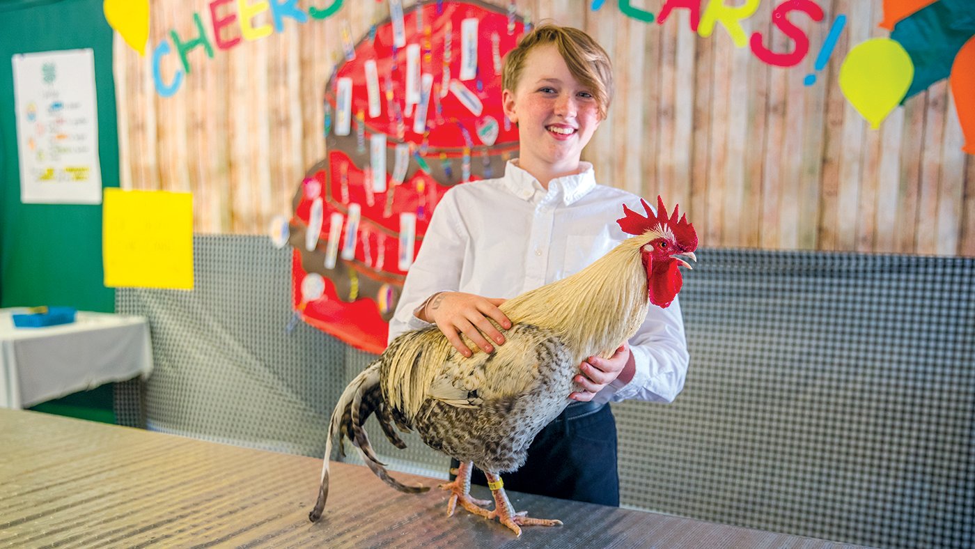 Leanne Sturgeon smiles for a photo while showing a rooster named Pepper alone Thursday at the Thurston County Fair as safety precautions remain in place to prevent the spread of avian influenza.
