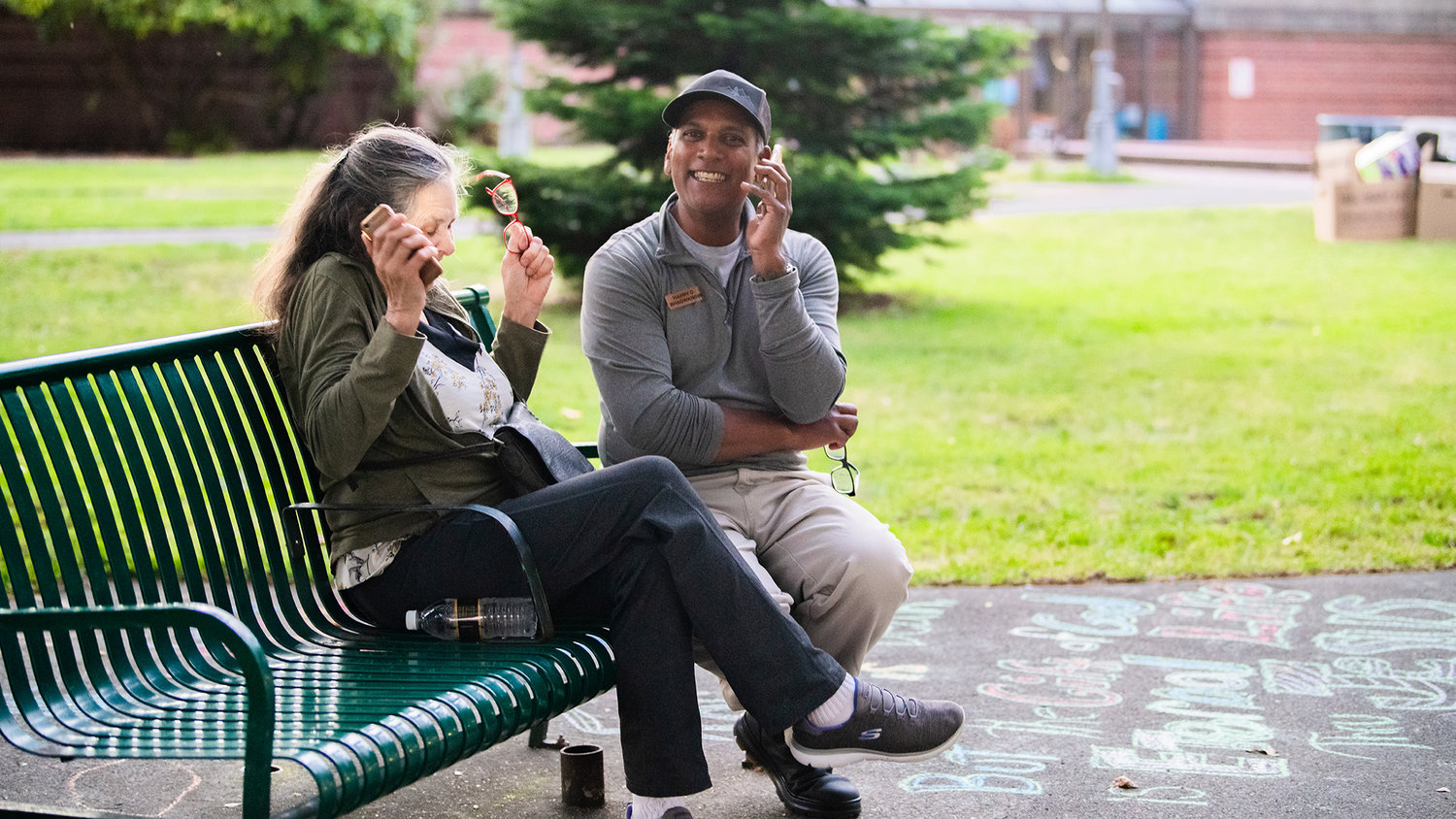 Lewis County Commissioner Candidate Harry Bhagwandin smiles while talking about election results with Bonnie Canaday, on the phone, Tuesday at George Washington Park in downtown Centralia. He's currently in second place to represent district 3 on the Board of County Commissioners.