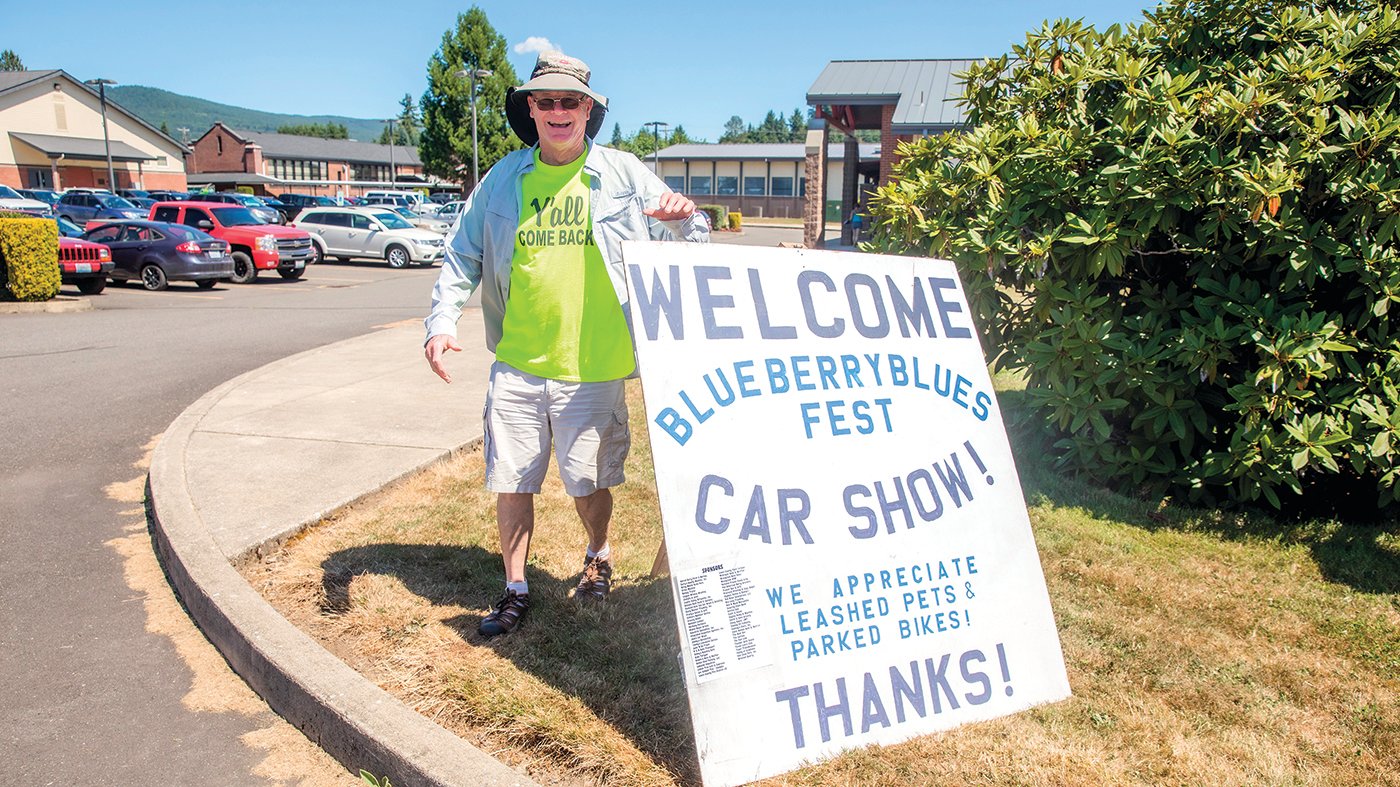 Dean Darnell welcomes visitors to the Blueberry Blues Fest Car Show in Mossyrock on Saturday with signage.