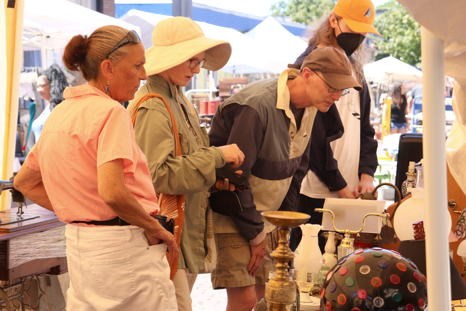 Marie Christensen, left, talks with perusing customers in her tent at Antique Fest in downtown Centralia on Sunday.