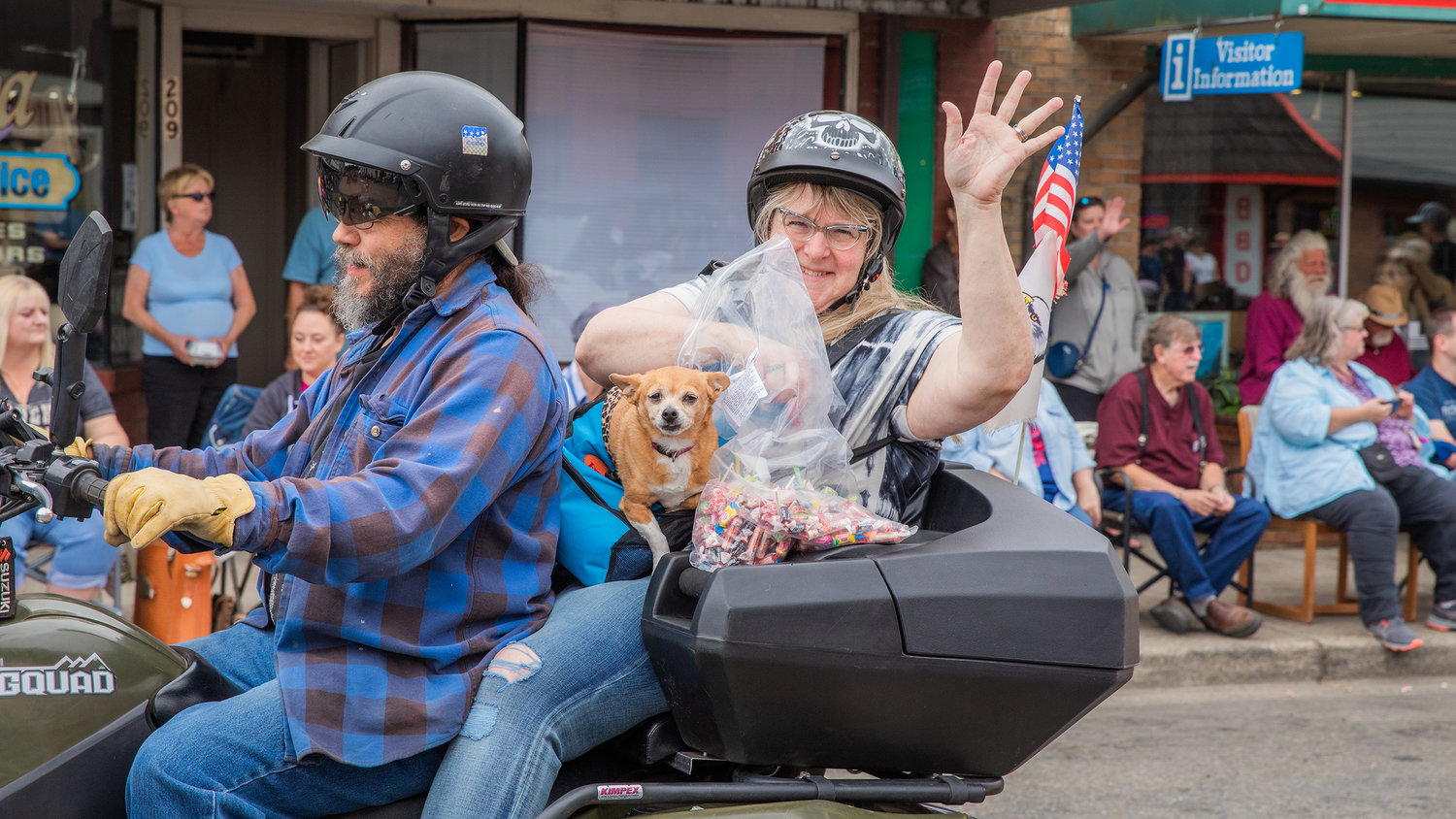 Riders smile and wave while passing out candy with their puppy Saturday during a parade in downtown Morton.