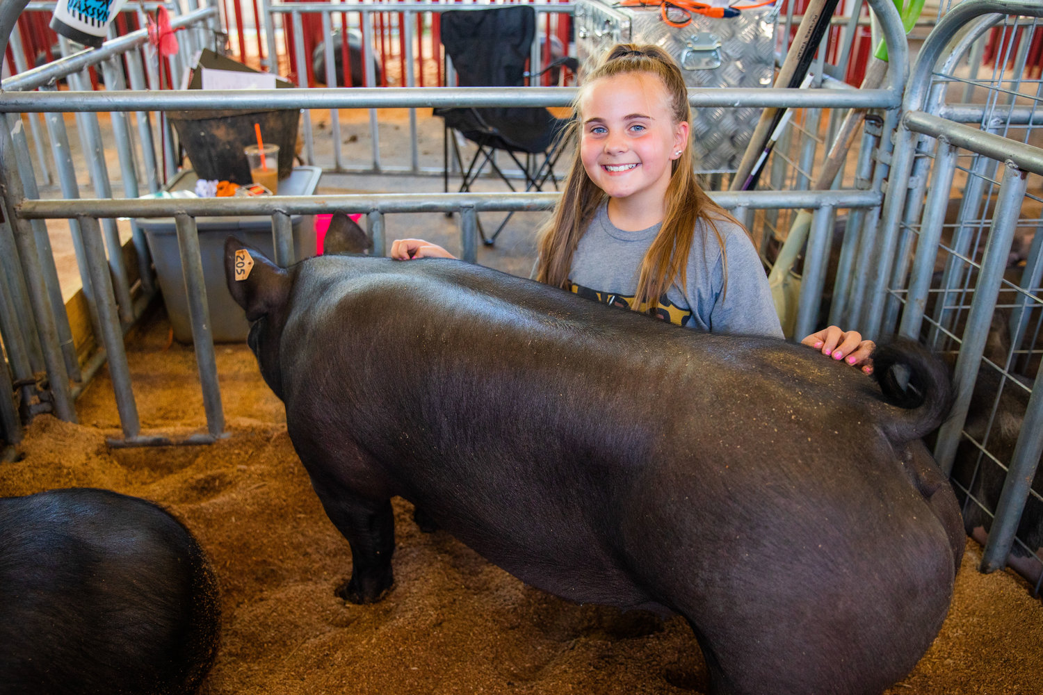 Little Miss Friendly candidate Jaxsyn Lowrey, 10, of Adna, smiles for a photo with her pig Nancy, a Hampshire and Yorkshire-mix, Monday afternoon at the Southwest Washington Fairgrounds in Centralia.