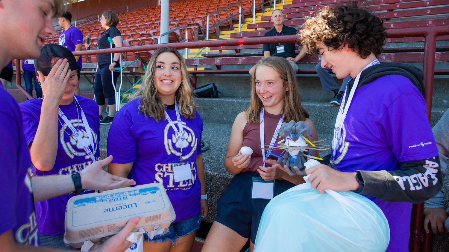 Lillian Hueffed, a W.F. West High School STEM student, receives her egg alongside partners who helped create a device to protect the shell from cracking during a drop Tuesday in Chehalis.