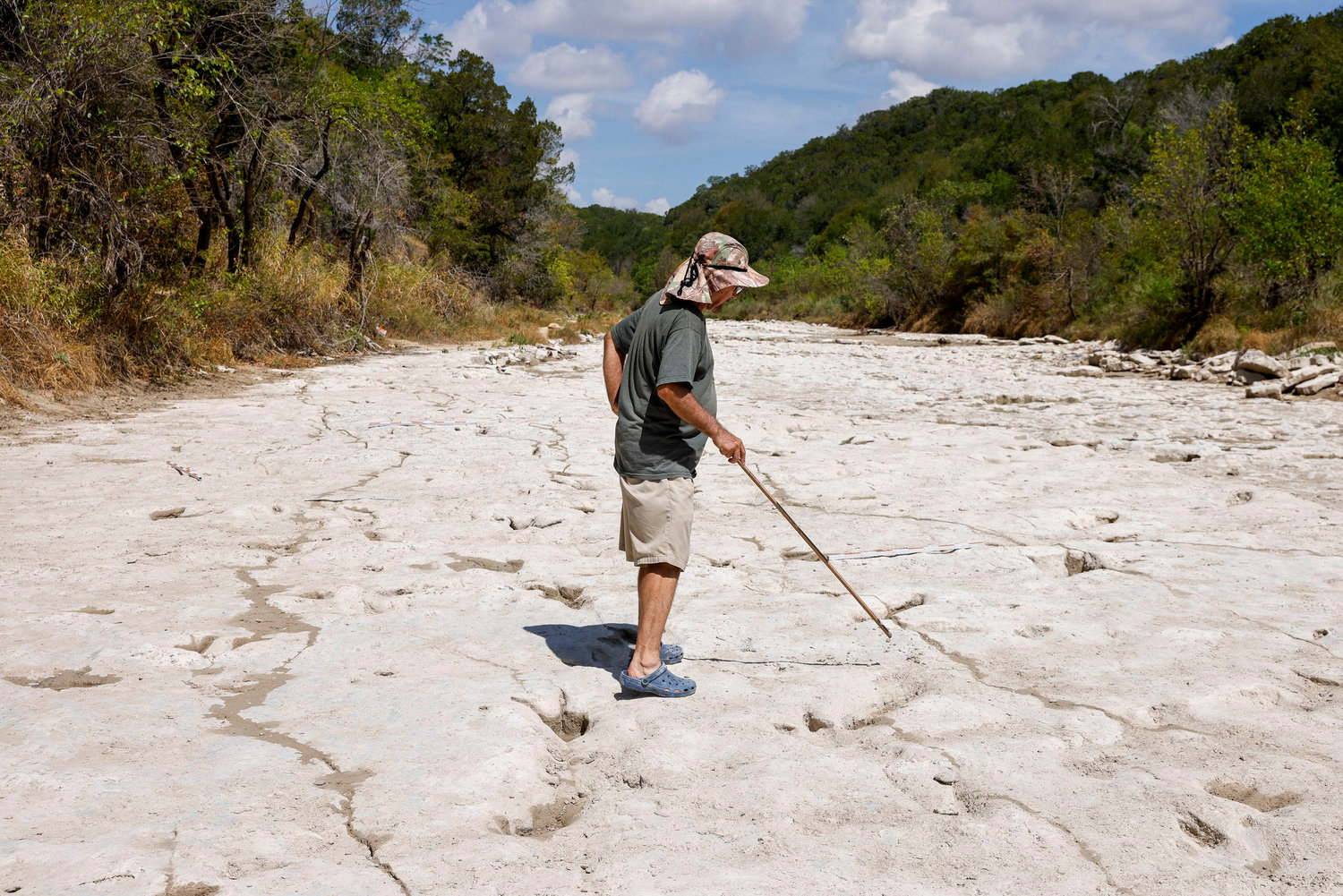 Dinosaur track researcher Glen Kuban points out various dinosaur tracks in the Paluxy River at Dinosaur Valley State Park in Glen Rose, Texas, Friday, Aug. 19, 2022. The recent drought lowered the level of the river and exposed dozens of tracks that were previously underwater. (Elías Valverde II/The Dallas Morning News/TNS)