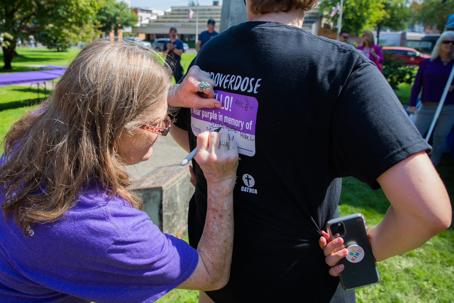 Deana Terrone writes “Shyla Towne” on the back of a shirt in memory of her daughter during an overdose awareness event at George Washington Park in Centralia on Wednesday.