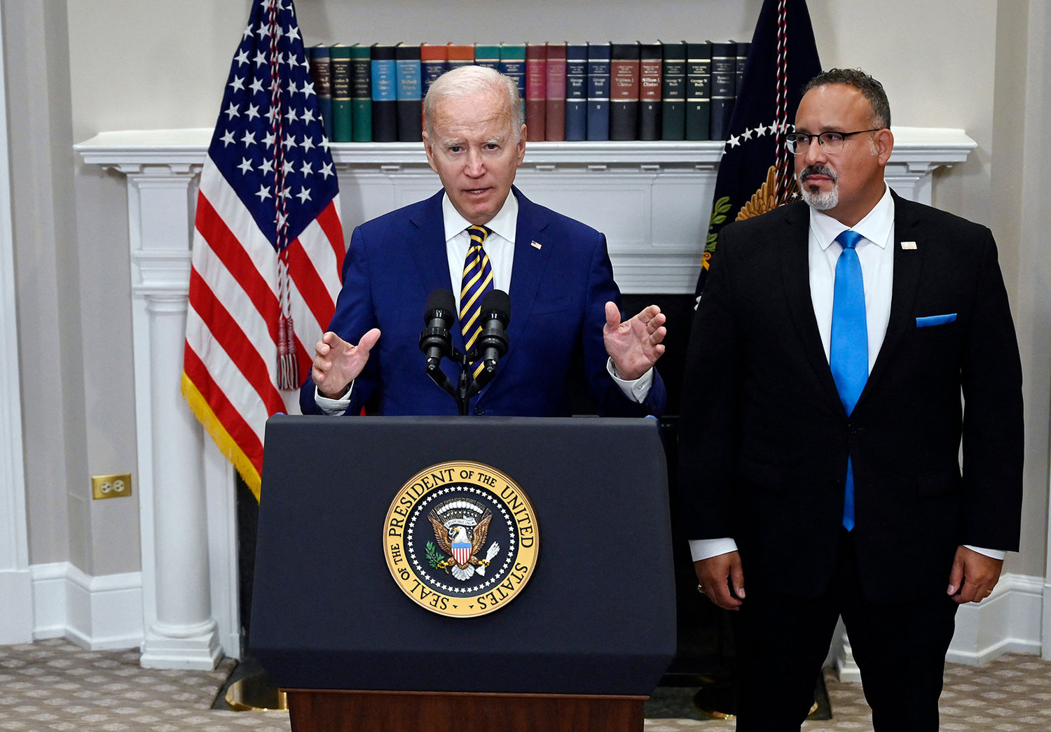 President Joe Biden announces student loan relief with Education Secretary Miguel Cardona, right, on Aug. 24, 2022, in the Roosevelt Room of the White House in Washington, D.C. (Olivier Douliery/AFP via Getty Images/TNS)