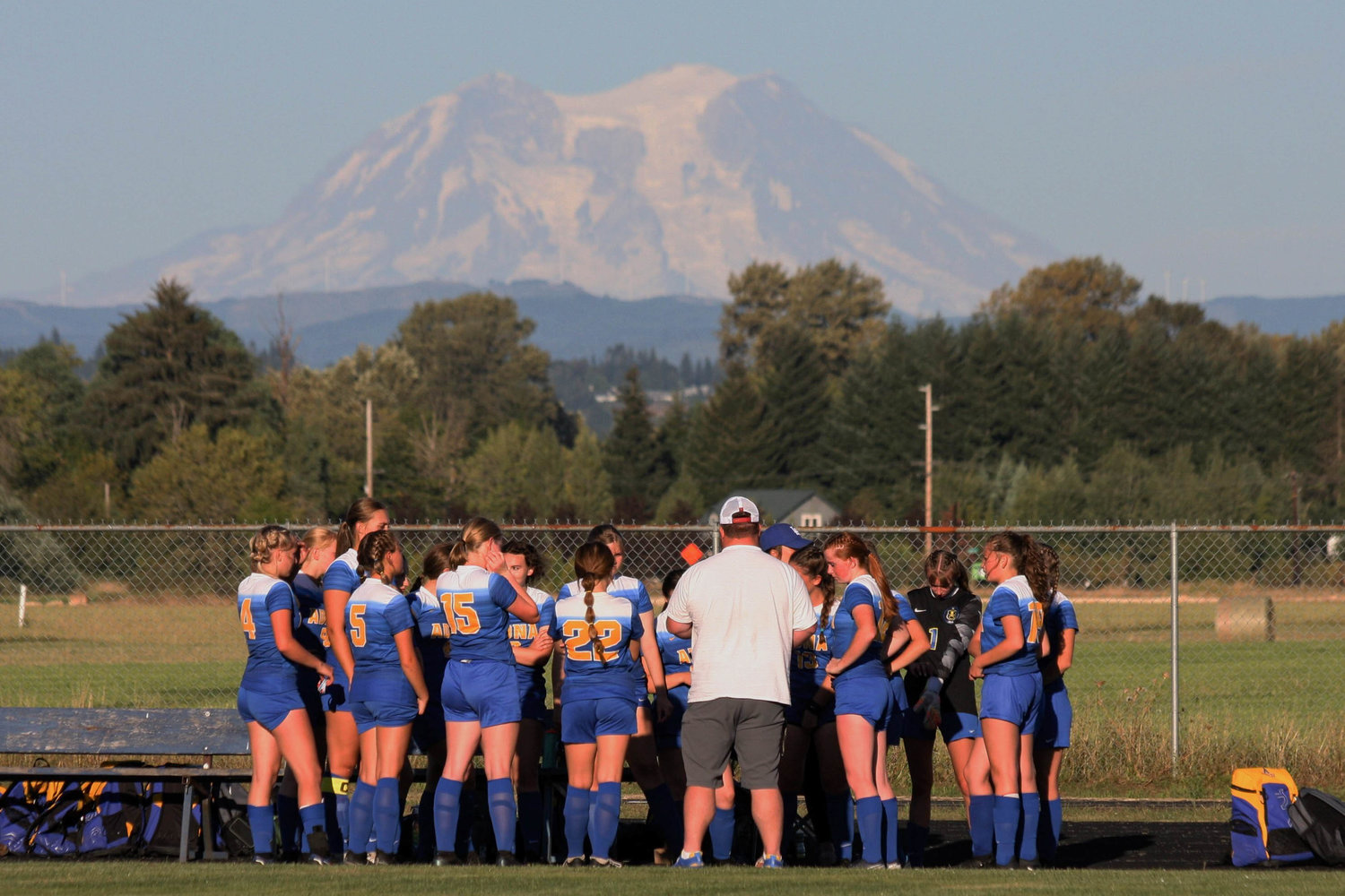 The Adna girls soccer team huddles around coach Patrick Richardson in a game against Elma Sept. 7.