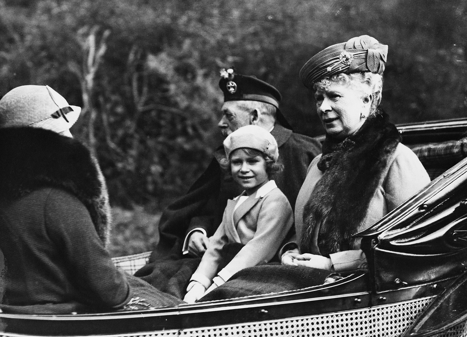 Princess Elizabeth (later Queen Elizabeth II) seated between her grandfather King George V (1865-1936) and grandmother Queen Mary of Teck (1867-1953) as they ride in a carriage back to Balmoral Castle from Crathie Kirk near Braemar in Scotland in August 1935. (Topical Press Agency/Getty Images/TNS)