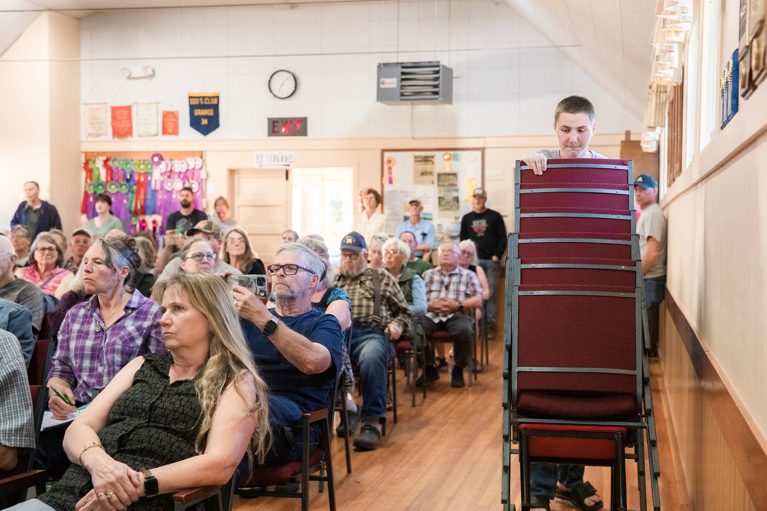 Chairs are wheeled out inside the Baw Faw Grange Thursday night as locals pile inside to hear about a county code change that would allow the research steps in the construction of a windmill farm.