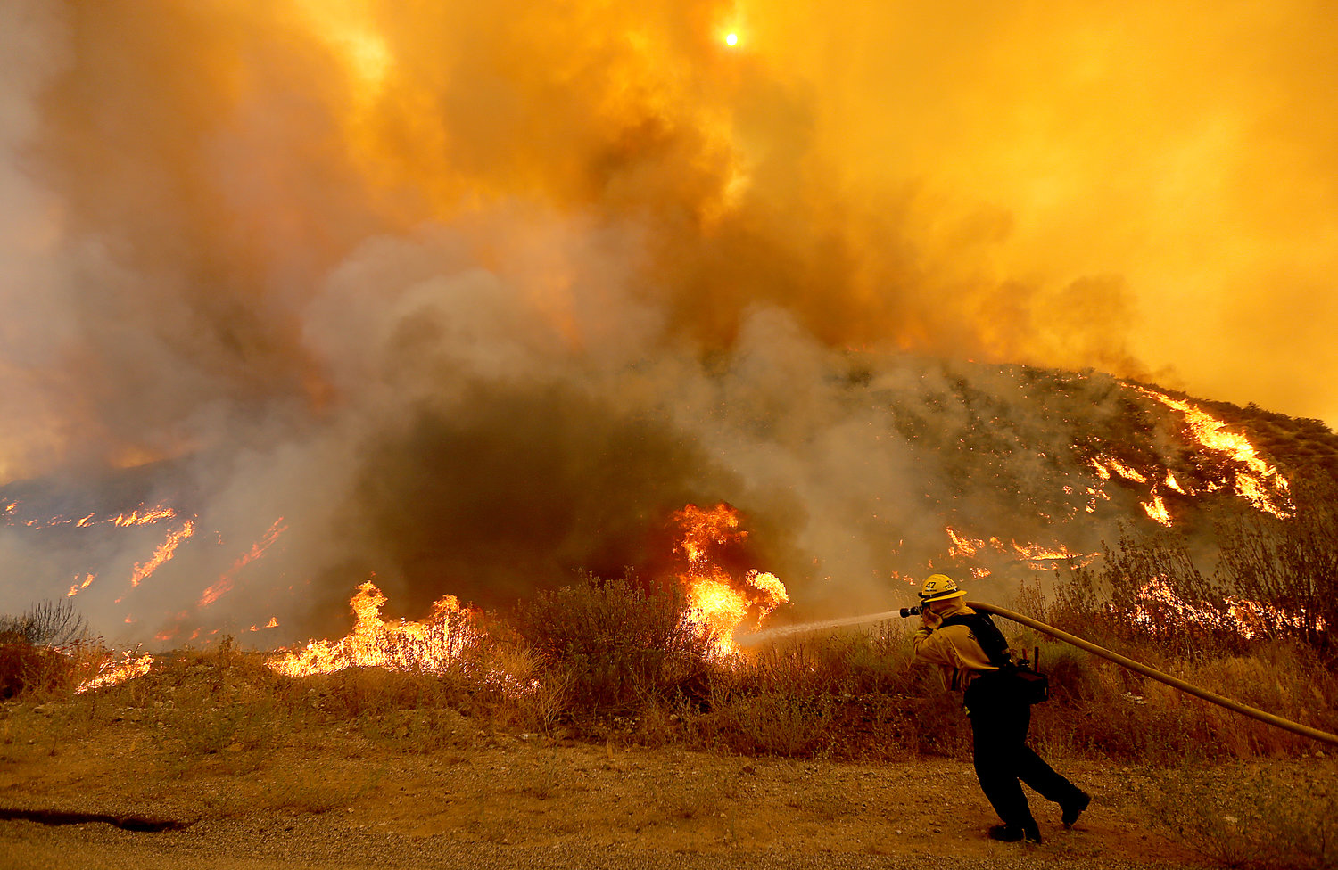 A firefighter battles the Fairview fire near Hemet recently. Experts say more communities will be threatened by catastrophic wildfires if officials don’t scale up mitigation efforts such as prescribed burning. (Luis Sinco/Los Angeles Times/TNS)
