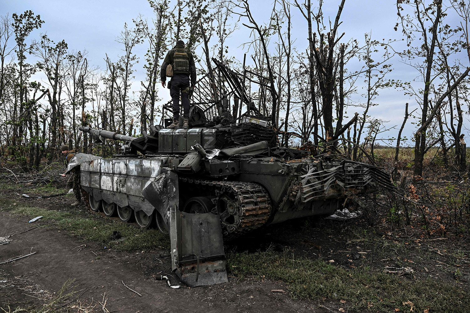 This photograph taken on Sept. 11, 2022, shows a Ukranian soldier standing atop an abandoned Russian tank near a village on the outskirts of Izyum, Kharkiv Region, eastern Ukraine, amid the Russian invasion of Ukraine. (Juan Barreto/AFP via Getty Images/TNS)