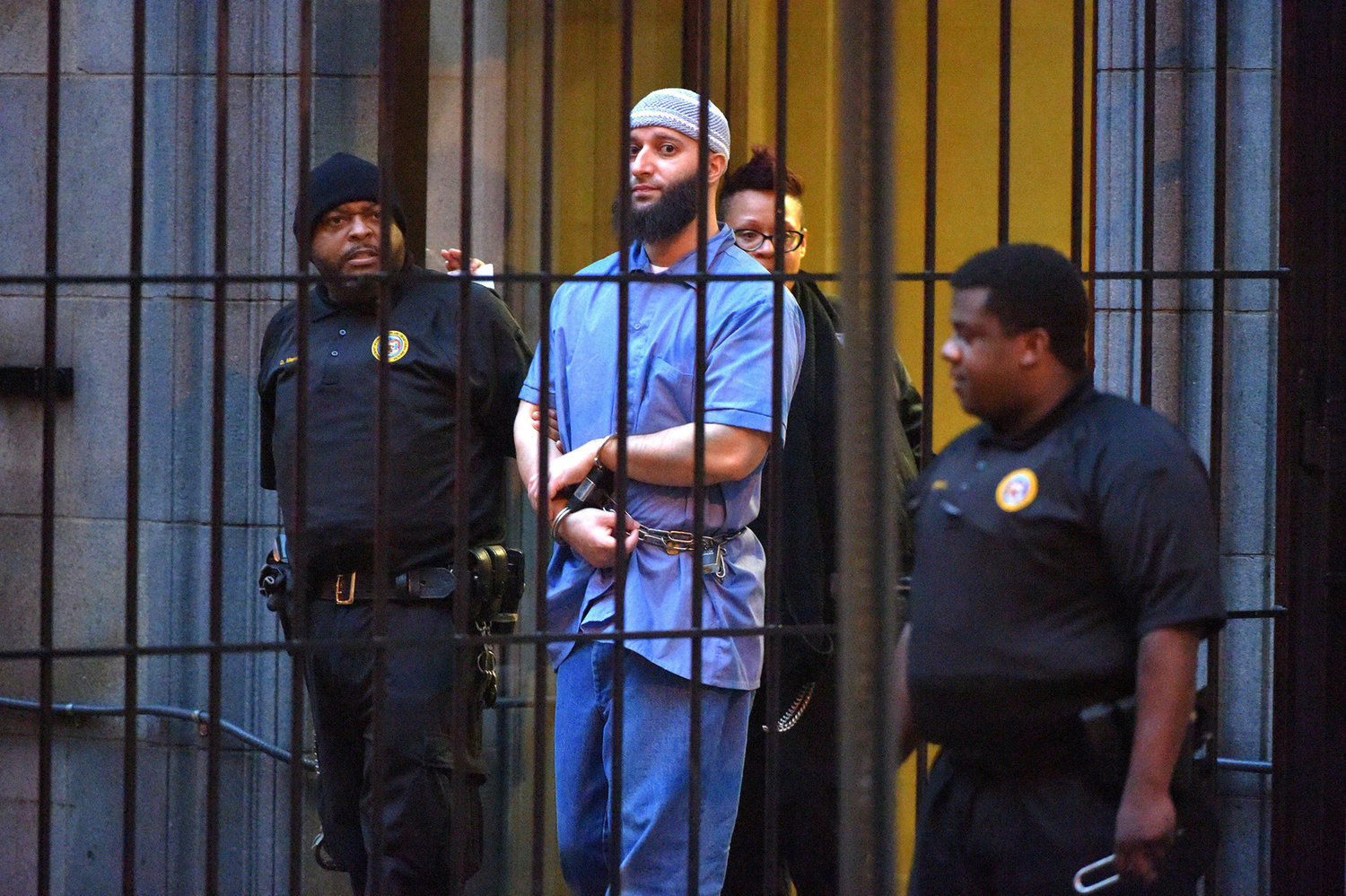 Officials escort "Serial" podcast subject Adnan Syed from the courthouse on Feb. 3, 2016, following the completion of the first day of hearings for a retrial in Baltimore. (Karl Merton Ferron/Baltimore Sun/TNS)