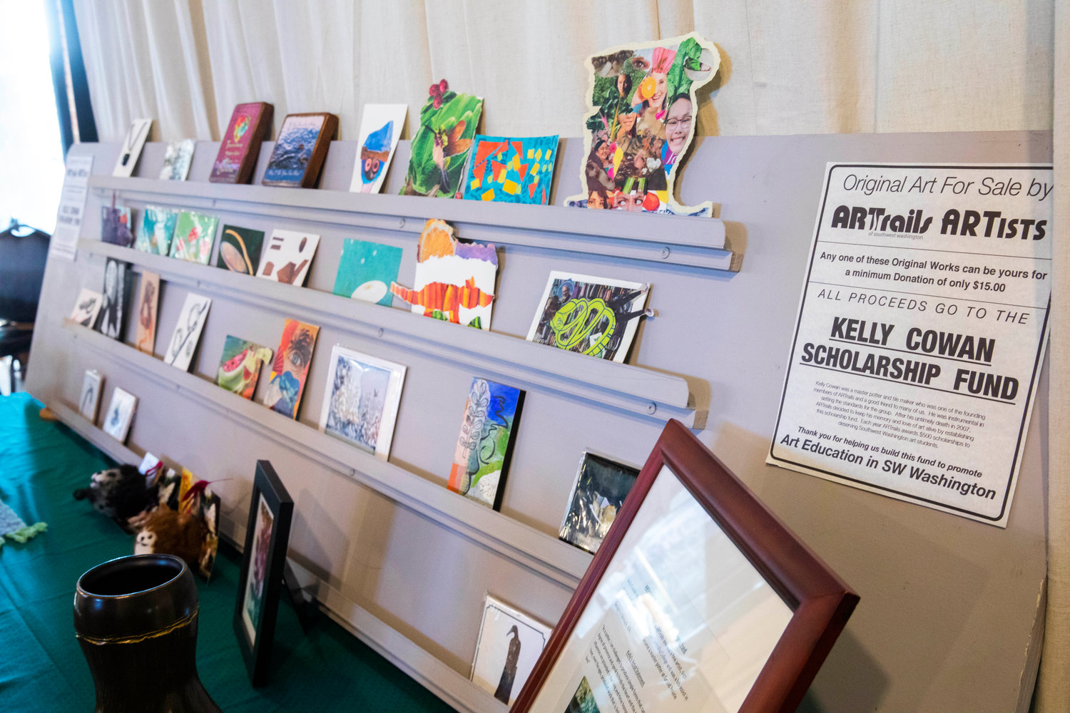 Original art pieces are exchanged by donation with proceeds benefiting the Kelly Cowan Scholarship Fund.
