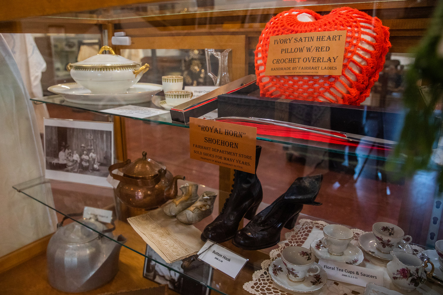 Clothing, decor, and fine china from the Fairhart family sits on display at the Morton Historical Museum alongside photographs.