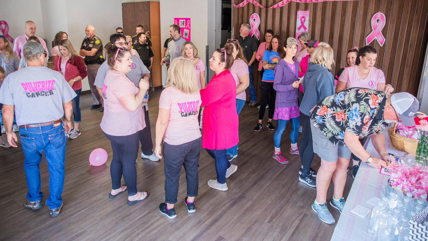 Participants mingle during an event at the Lewis County Law and Justice Center for Breast Cancer Awareness Month Friday morning in Chehalis.