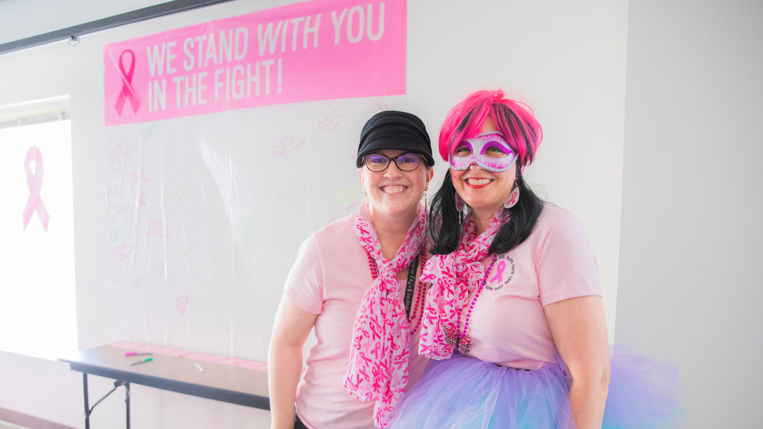 Lori Pulver, left, smiles for a photo with attendees decked out in pink hues for Breast Cancer Awareness Month Friday morning in Chehalis.