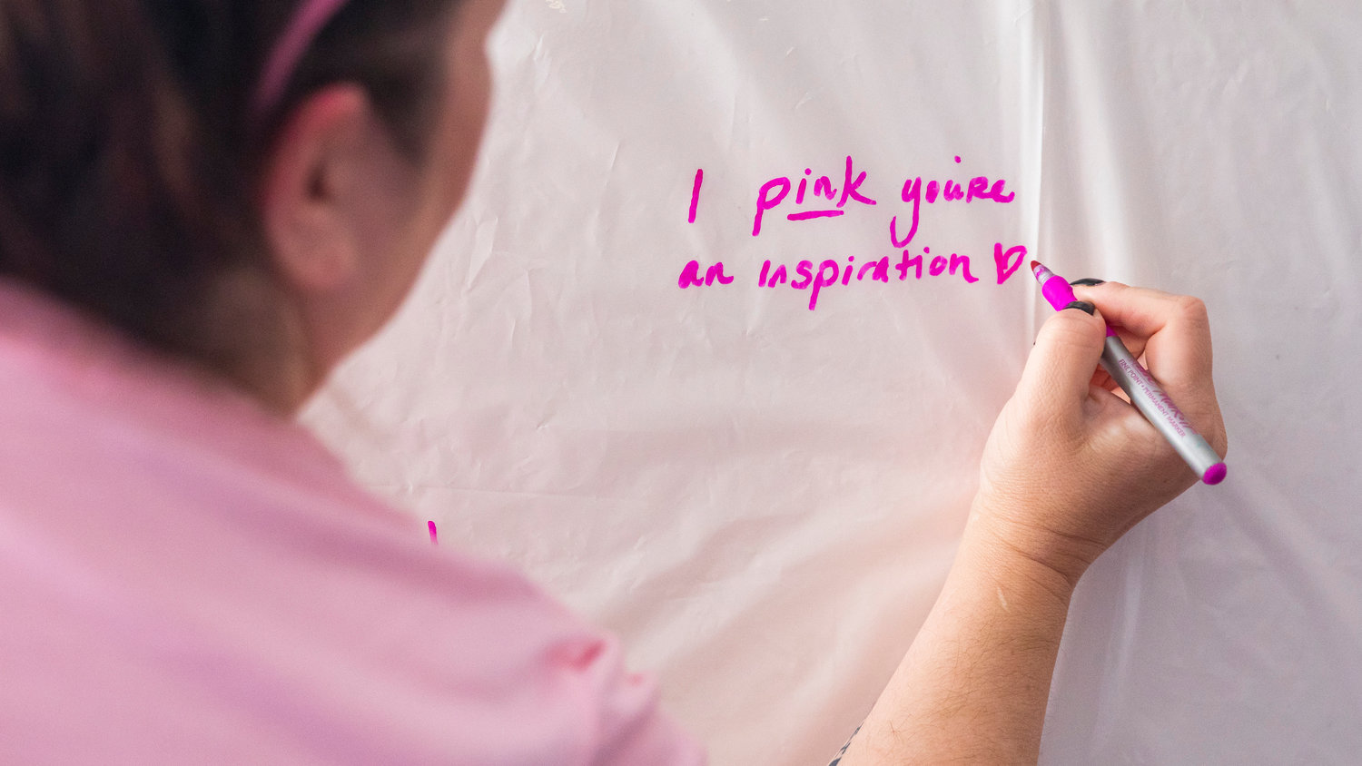 Rieva Lester writes a message for Lori Pulver during a Breast Cancer Awareness Month event at the Lewis County Law and Justice Center on Friday.