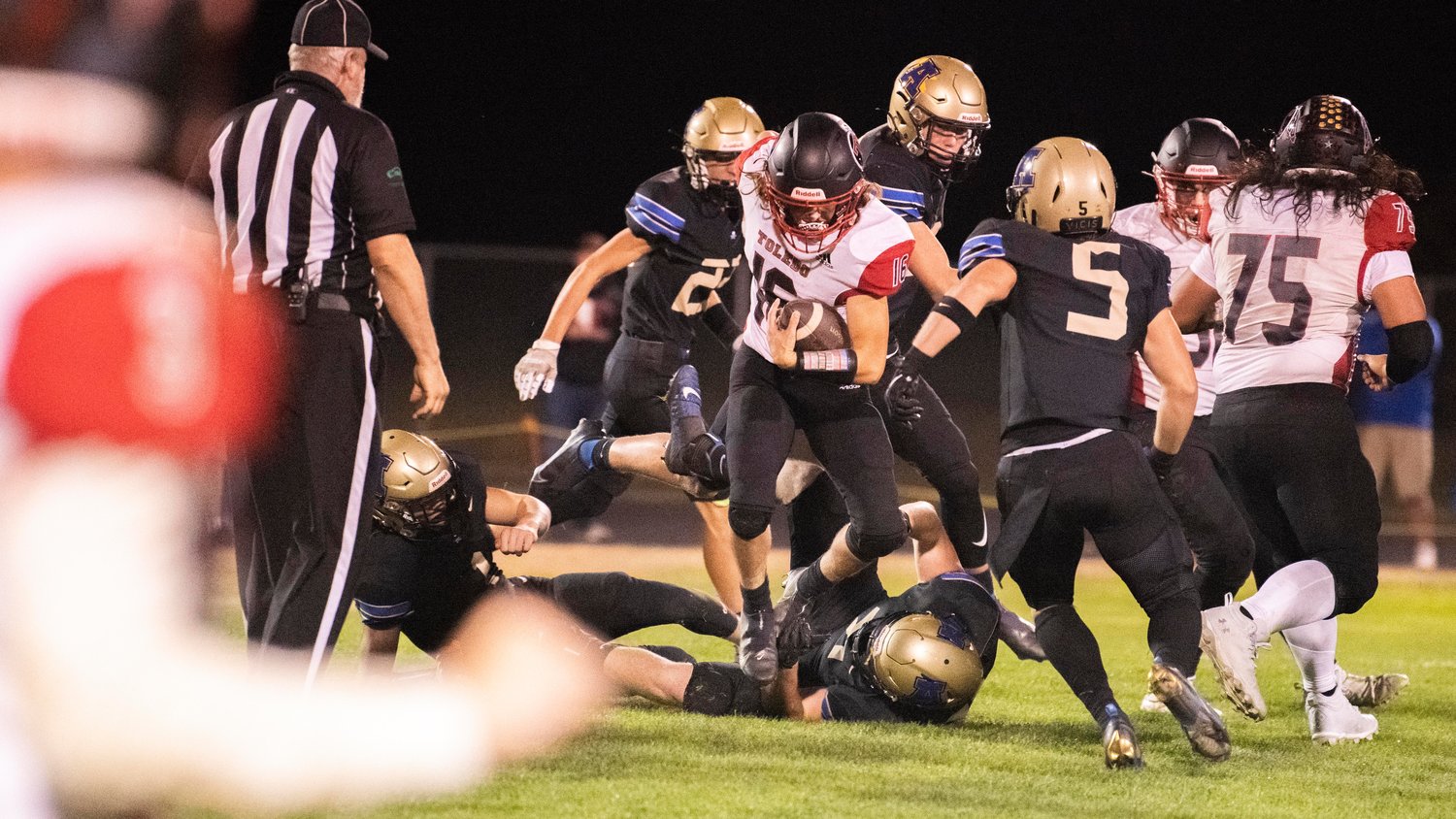 Toledo senior Zane Ranney (16) plows through defenders with the football Friday night in Adna.
