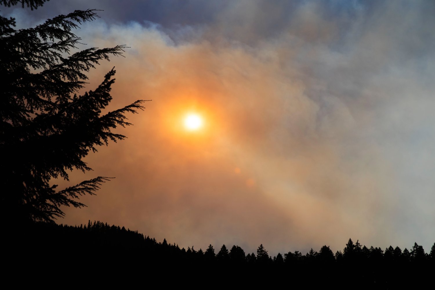 The sun shines through smoke from the Goat Rocks Fire on Sunday as seen from the Palisades Viewpoint off U.S. Highway 12 near Packwood Sunday.