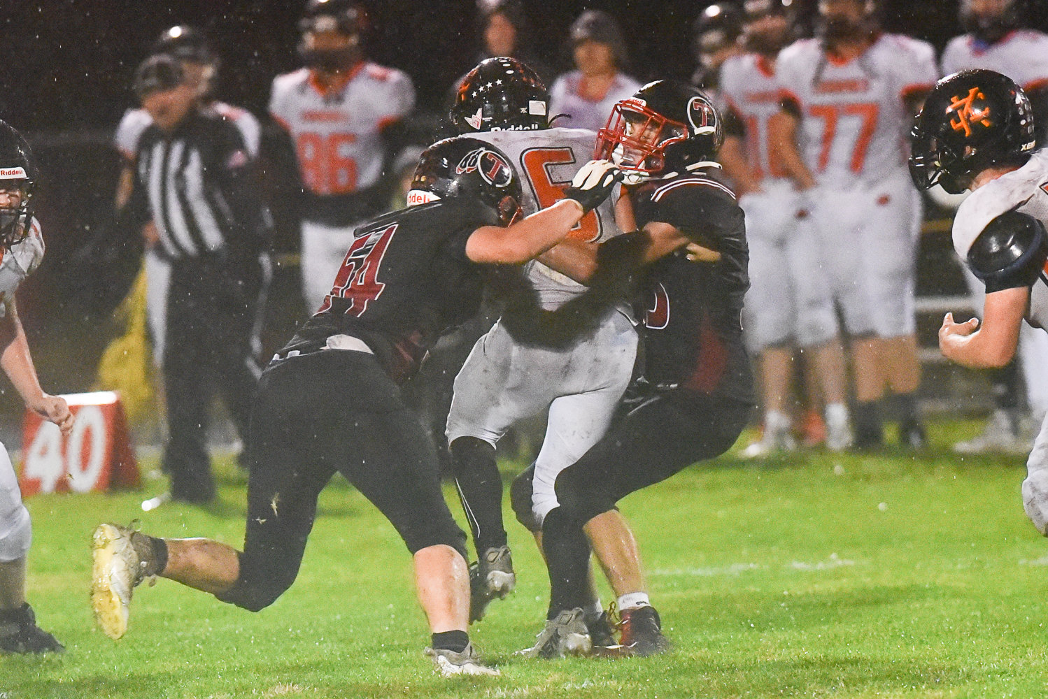Toledo's Bayron Rodriguez (54) and Trevin Gale (33) meet at Kalama quarterback Aiden Brown for a sack during the second half of the Riverhawks' 35-0 win over the Chinooks on Oct. 21.