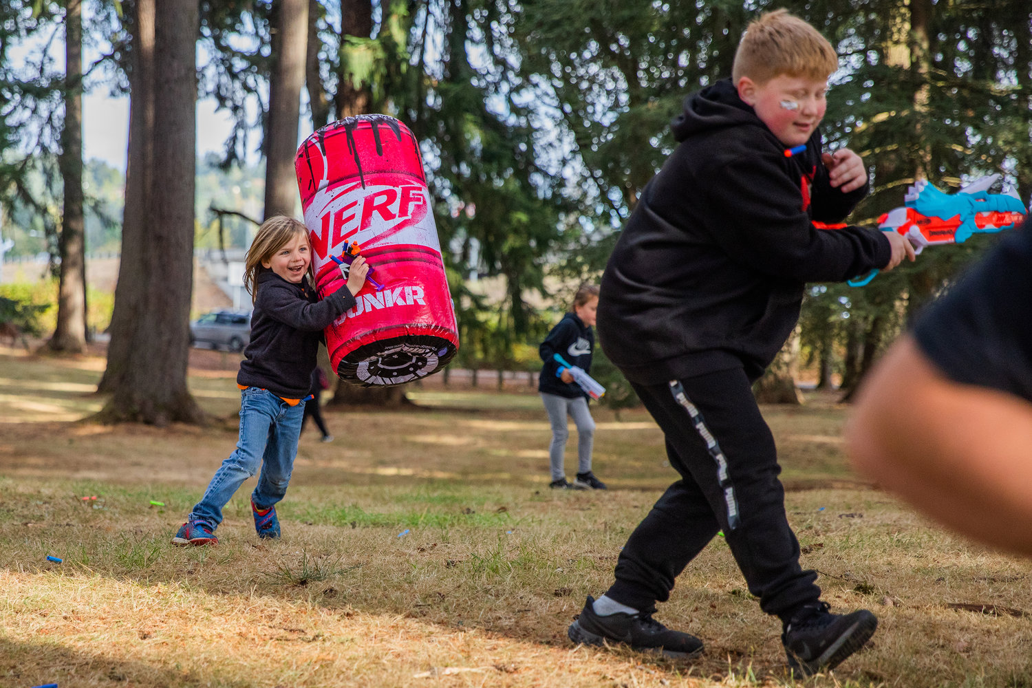 Bullets fly as kids laugh while attempting to dodge and hide Sunday during a Nerf War at Borst Park in Centralia.