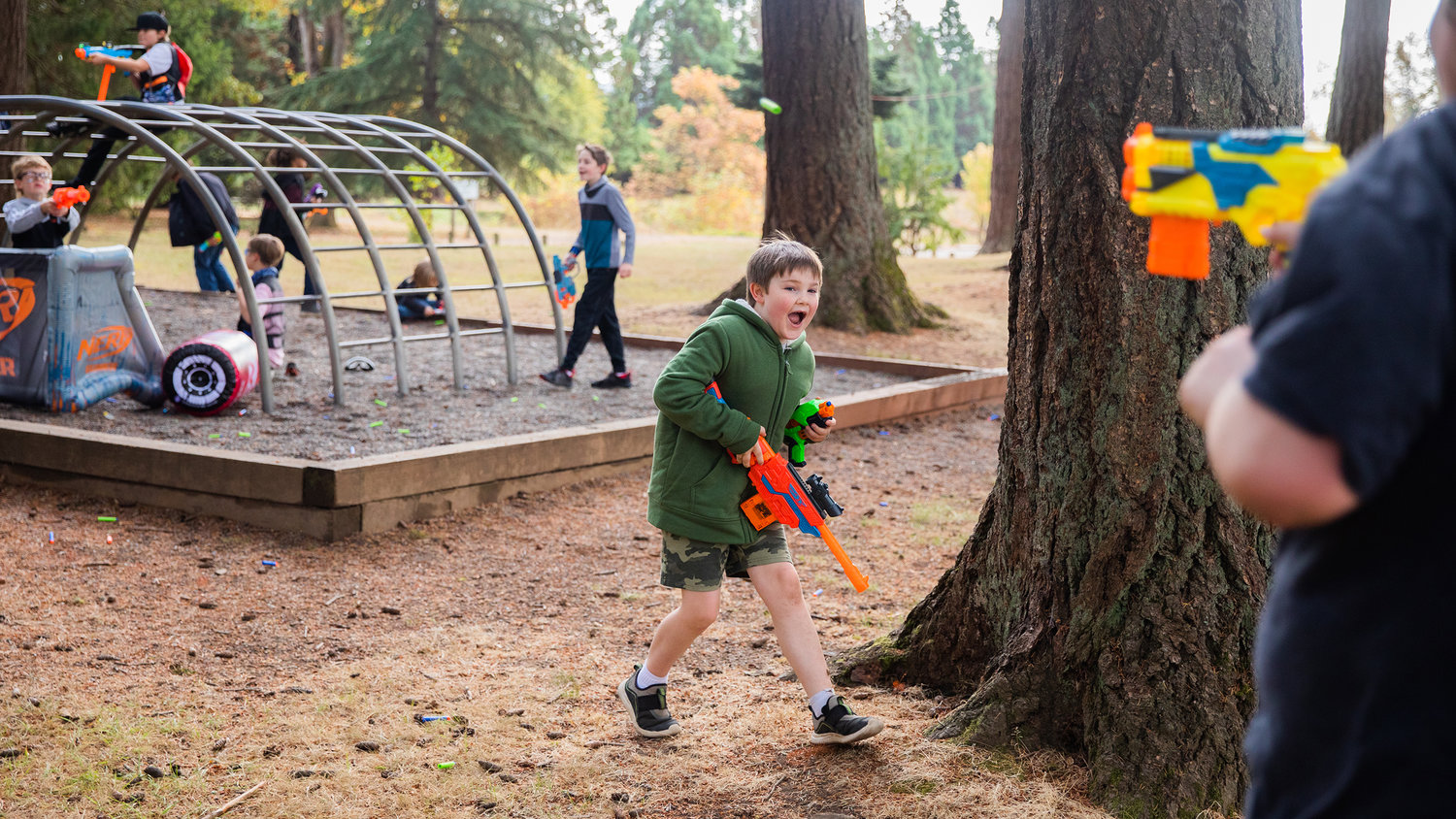Kids look to return fire during a Nerf War at Borst Park on Sunday.