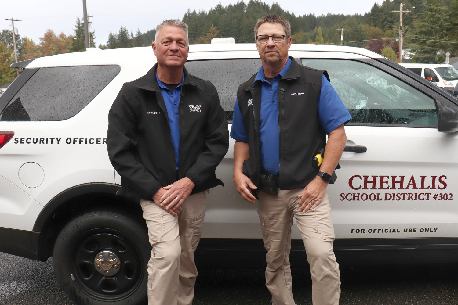 Chehalis School Security Officers Troy and Todd Thornburg pose in front of their vehicle parked outside W.F. West High School on Monday.