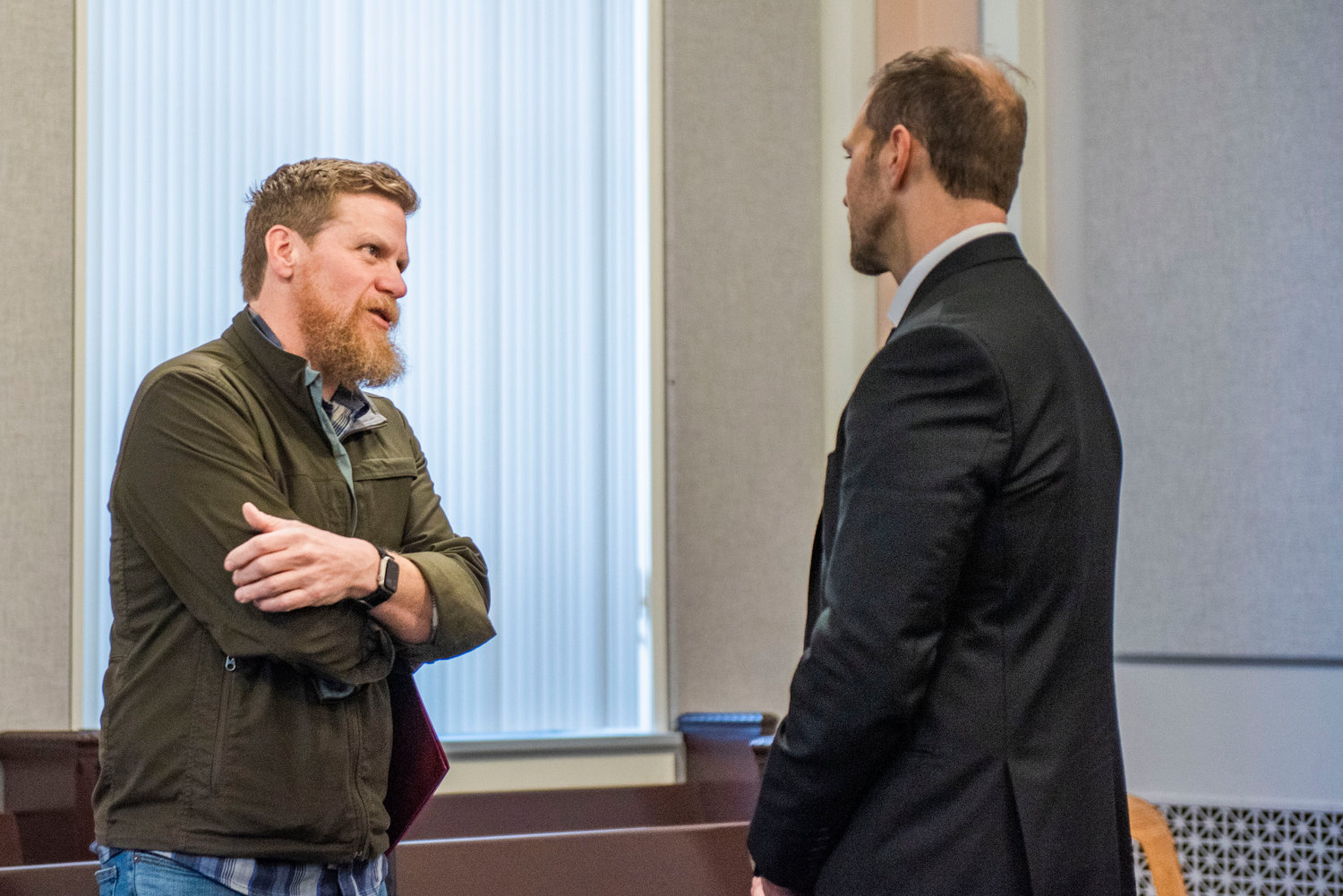 Commissioner Sean Swope approaches and listens to Cole Meckle, pastor at Gather Church in Centralia — which has run the county’s coordinated entry program among other services for homelessness — ahead of Tuesday morning meetings in the Lewis County Commissioners’ Hearing room in Chehalis.