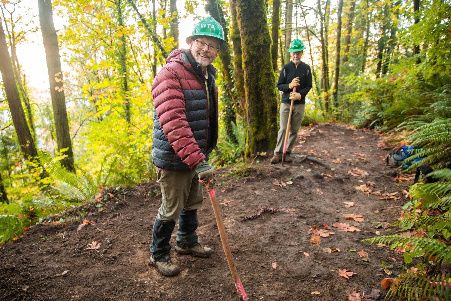 Olympia residents Tom Roalkvam, left, smiles alongside Randy Thorn while doing volunteer trail work at the Seminary Hill Natural Area in Centralia on Wednesday.