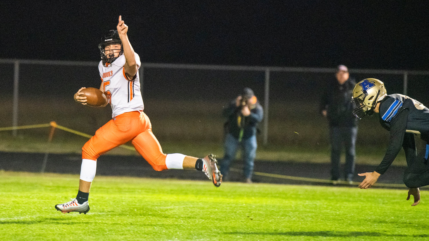 Kalama quarterback Aiden Brown (6) holds up a finger while running for the end zone Thursday night during a game against Adna at Pirate Stadium.