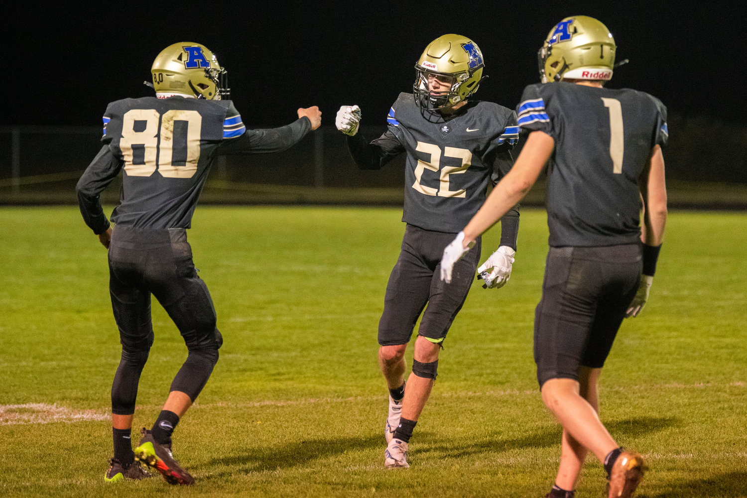 Adna players fist-bump during a game Thursday night at Pirate Stadium.