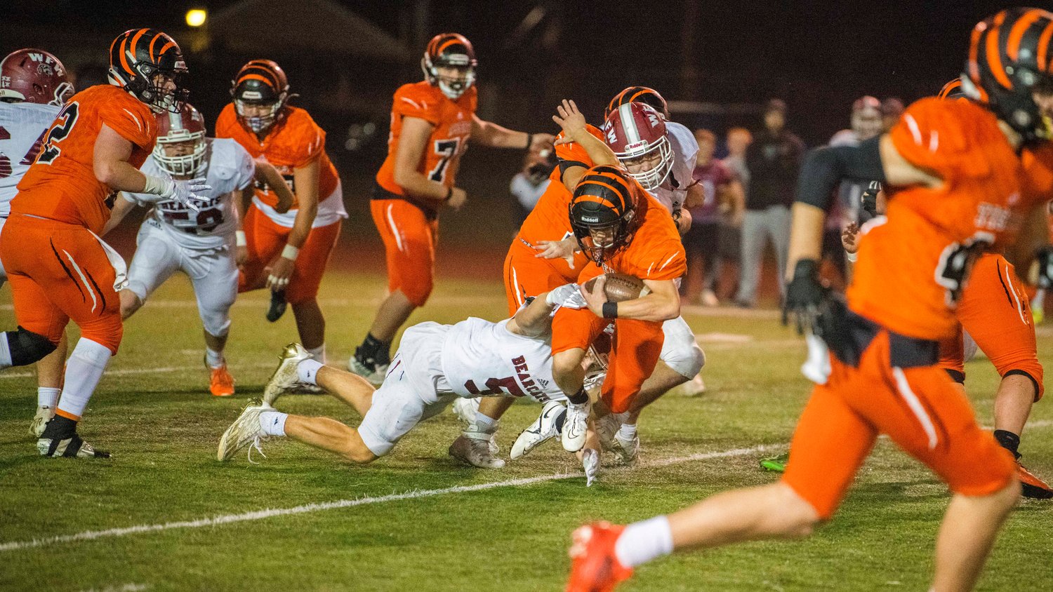 Centralia sophomore Kellen Rooklidge (22) busts through the Bearcat defense before being brought down under Friday night lights.