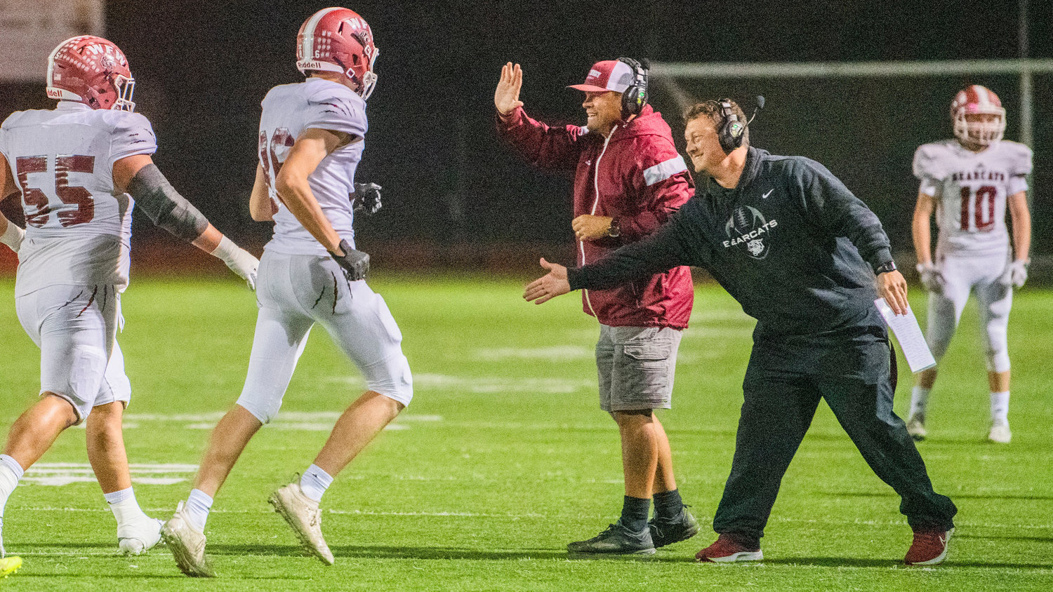 Bearcat coaches greet players with high-fives after a score Friday night in Centralia.