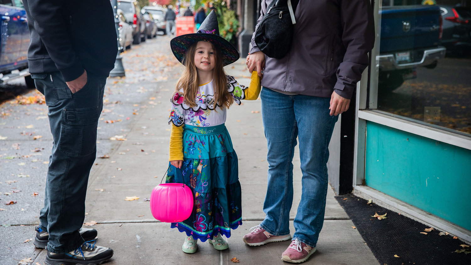 Ellie Hynes, 4, walks with her parents John and Katie while trick-or-treating in downtown Centralia on Halloween.