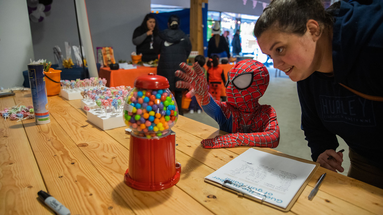 Spidey-Sense is used in guessing the number of gum balls in a dispenser during a Halloween Carnival at The White Space in downtown Centralia on Monday.