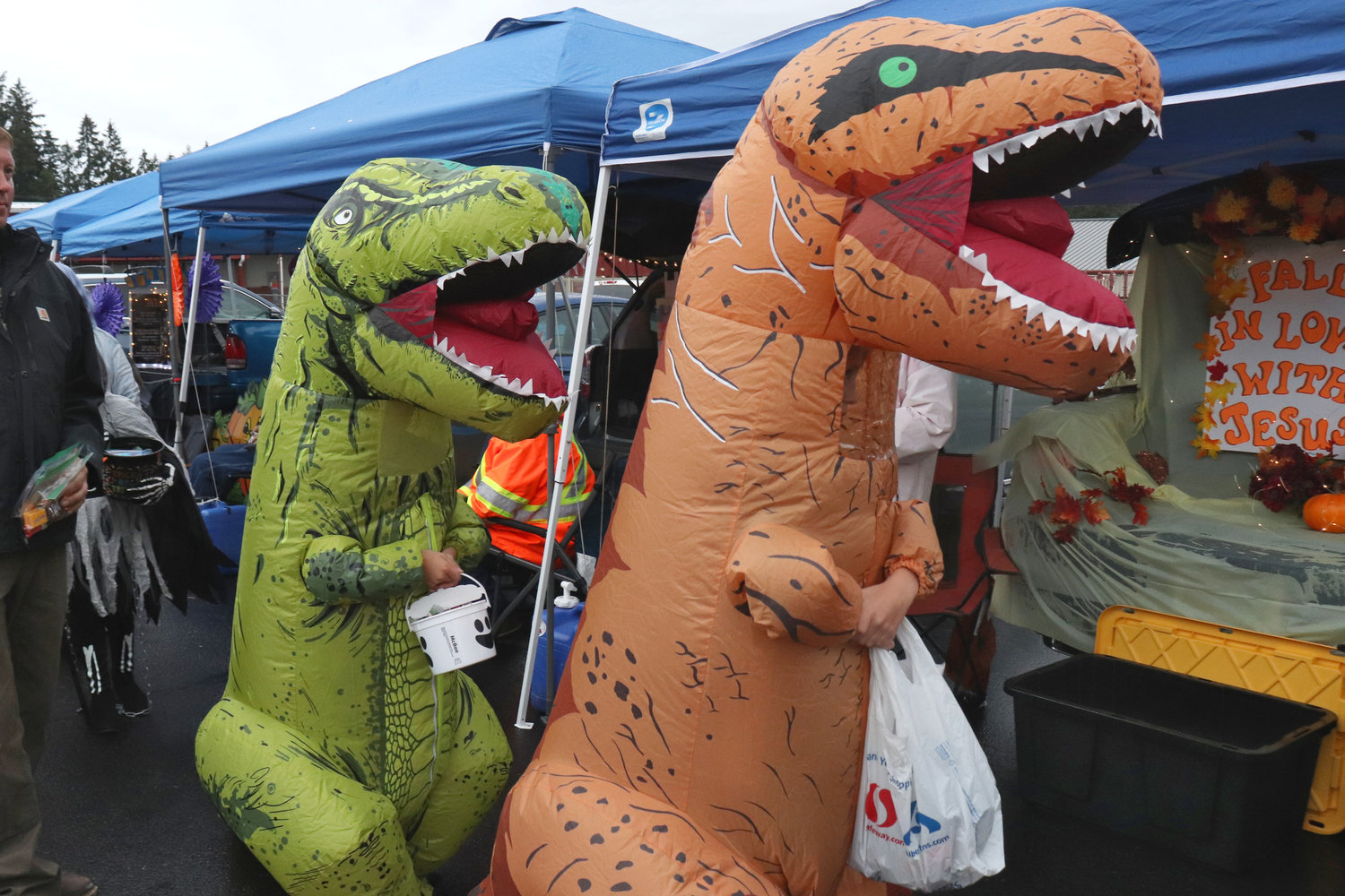 Dinosaurs go between cars to get candy at Napavine Assembly of God Church’s trunk or treat event on Monday.