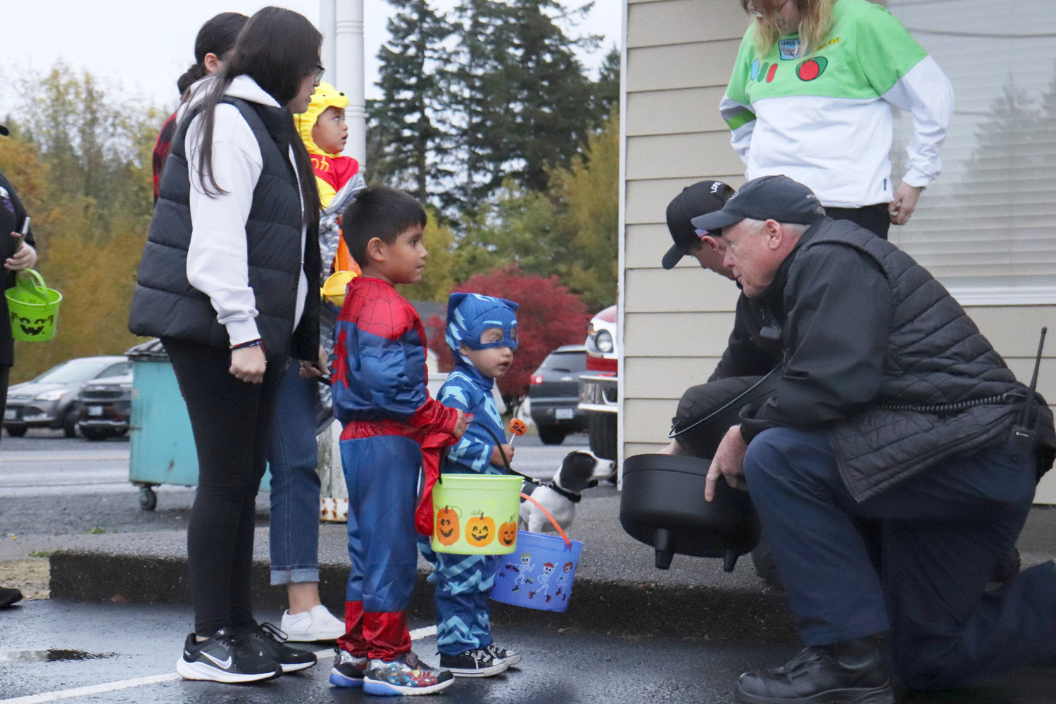 Lewis County Fire District 5 Chief Dan Mahoney kneels down to talk with trick-or-treaters during a trunk or treat event in Napavine on Monday.