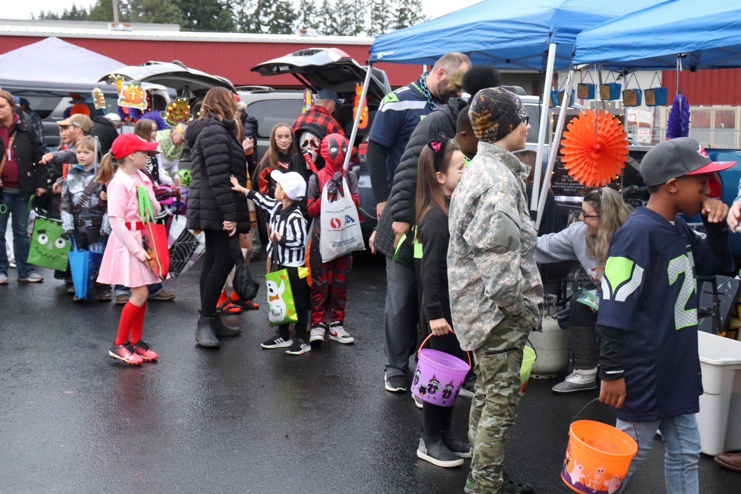 Trick-or-treaters go between cars for candy at Napavine Assembly of God Church’s trunk or treat event on Monday.