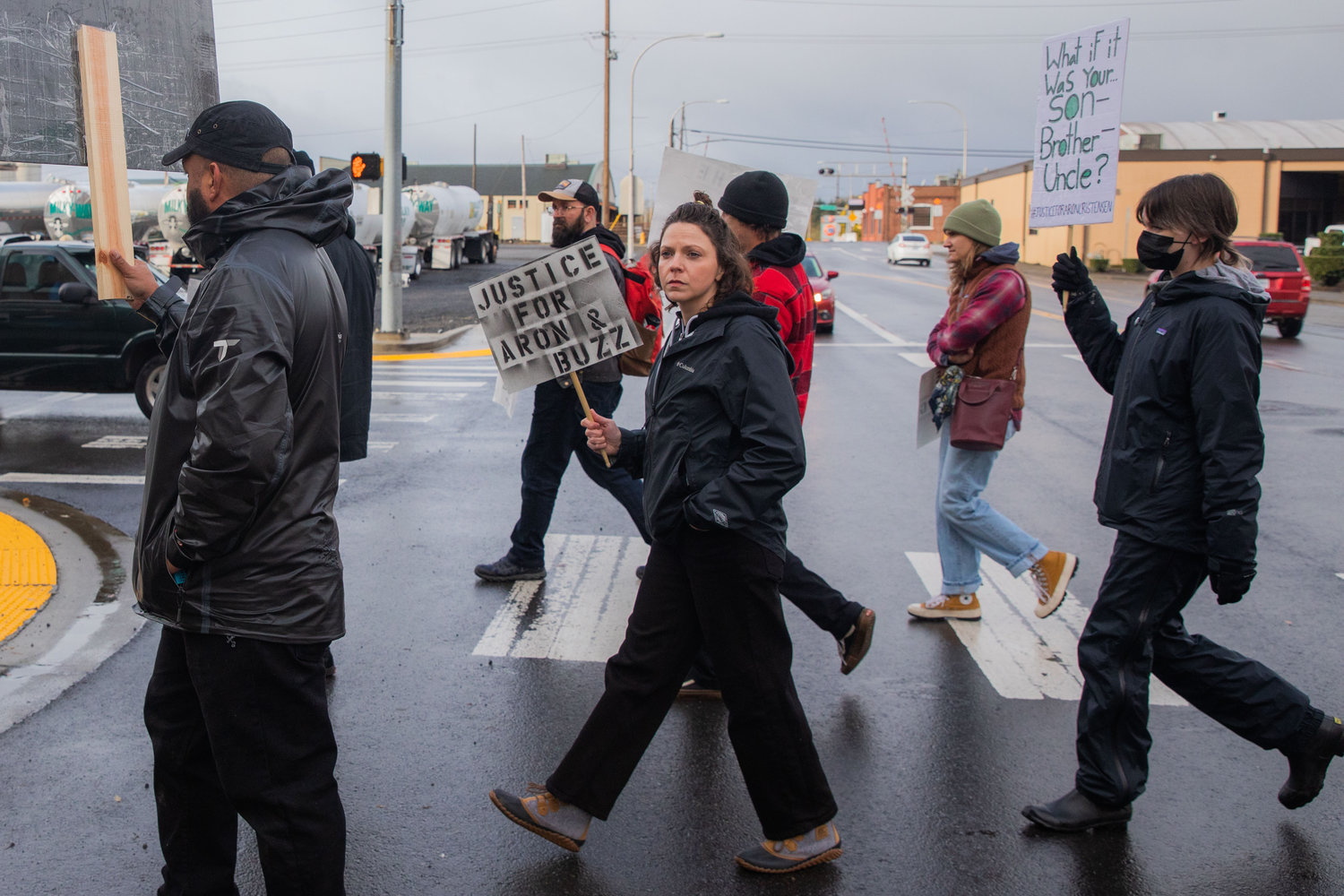Demonstrators walk through the rain to the Lewis County Law and Justice Center in Chehalis on Saturday while demanding justice for Aron Christensen and his dog Buzz.