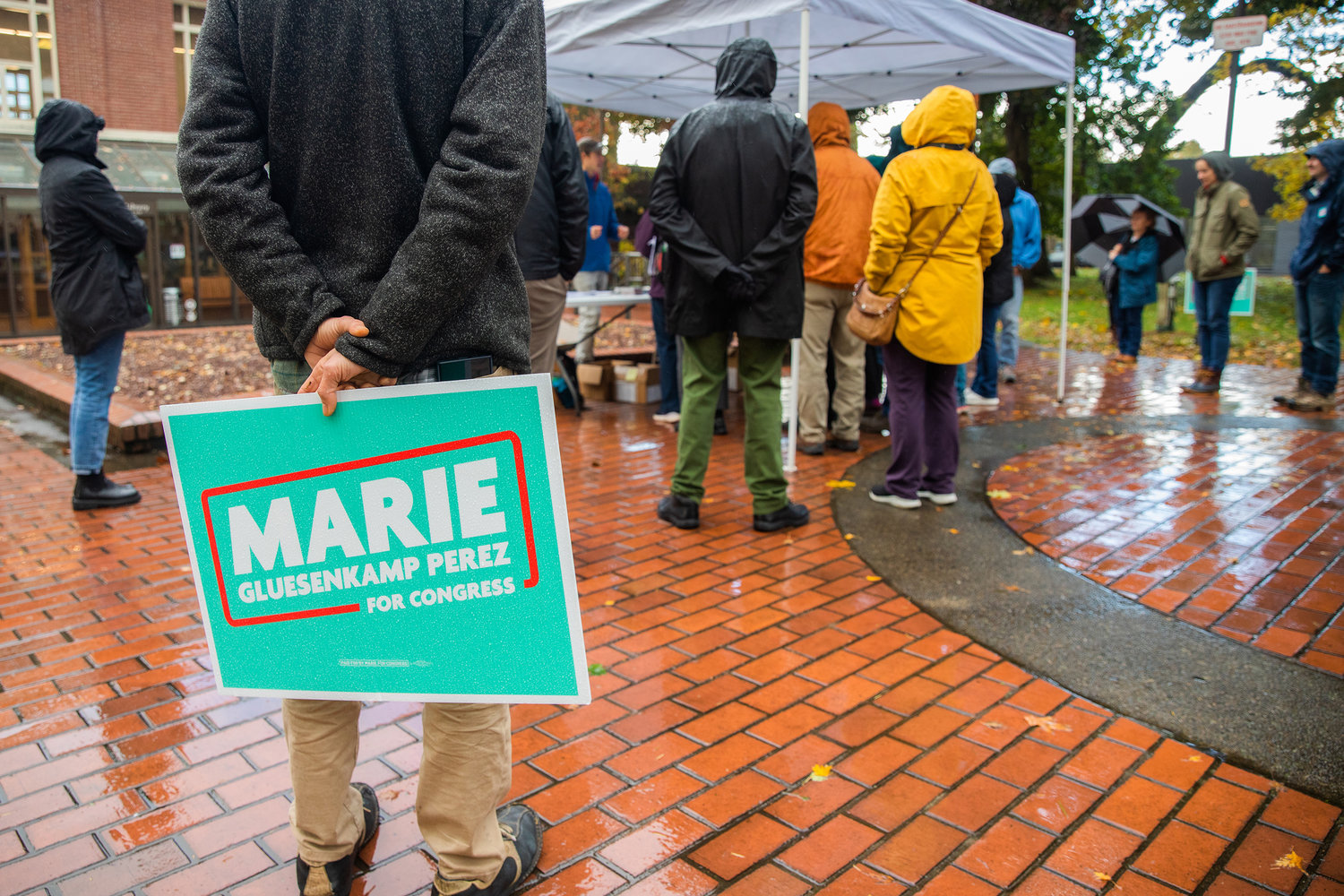 Marie Gluesenkamp Perez campaign signs are held during a visit Saturday afternoon outside the Centralia Timberland Library.